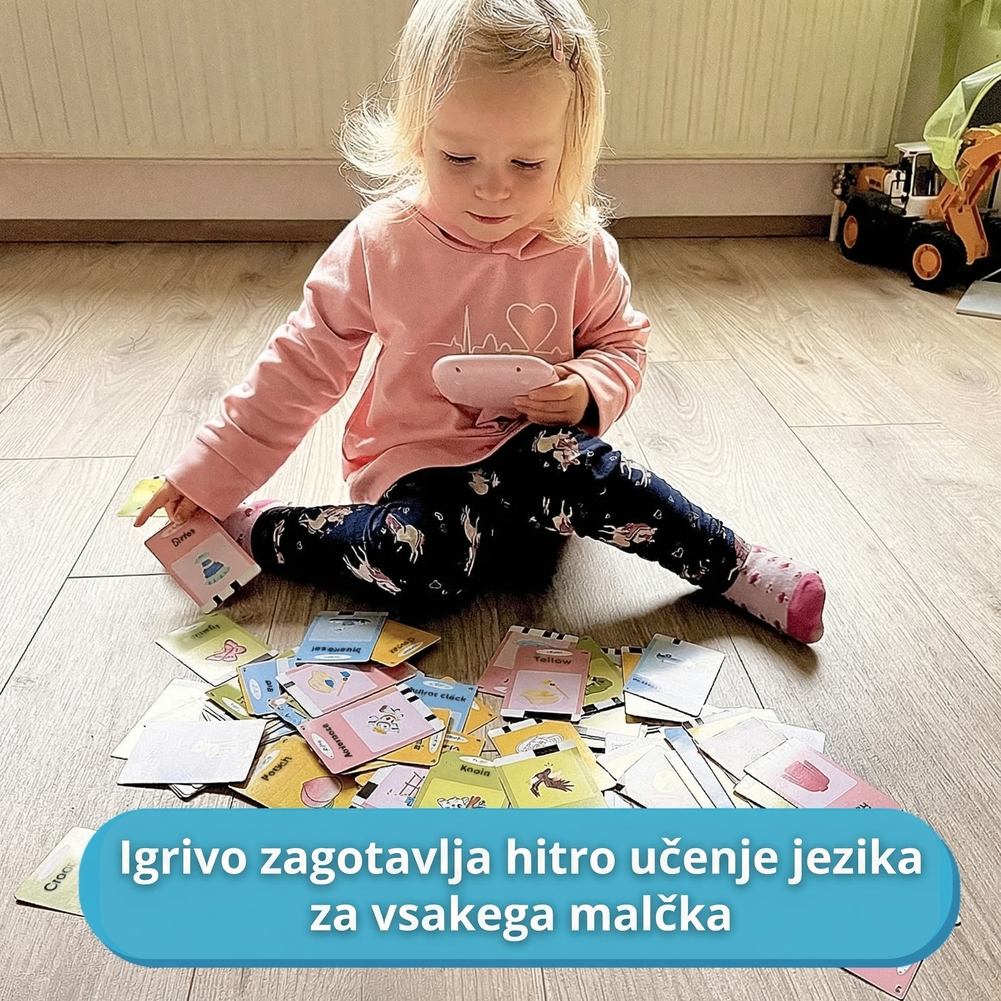 Malčica med igro z interaktivno napravo in številnimi tematskimi karticami, ki na igriv način zagotavljajo hitro učenje jezika.