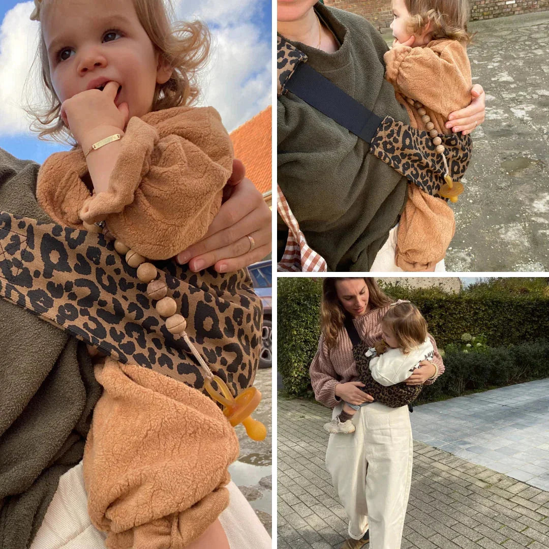 Otroška nosilka z leopardjim vzorcem, ki staršu omogoča varno in udobno nošenje malčka na boku med vsakodnevnimi opravili.